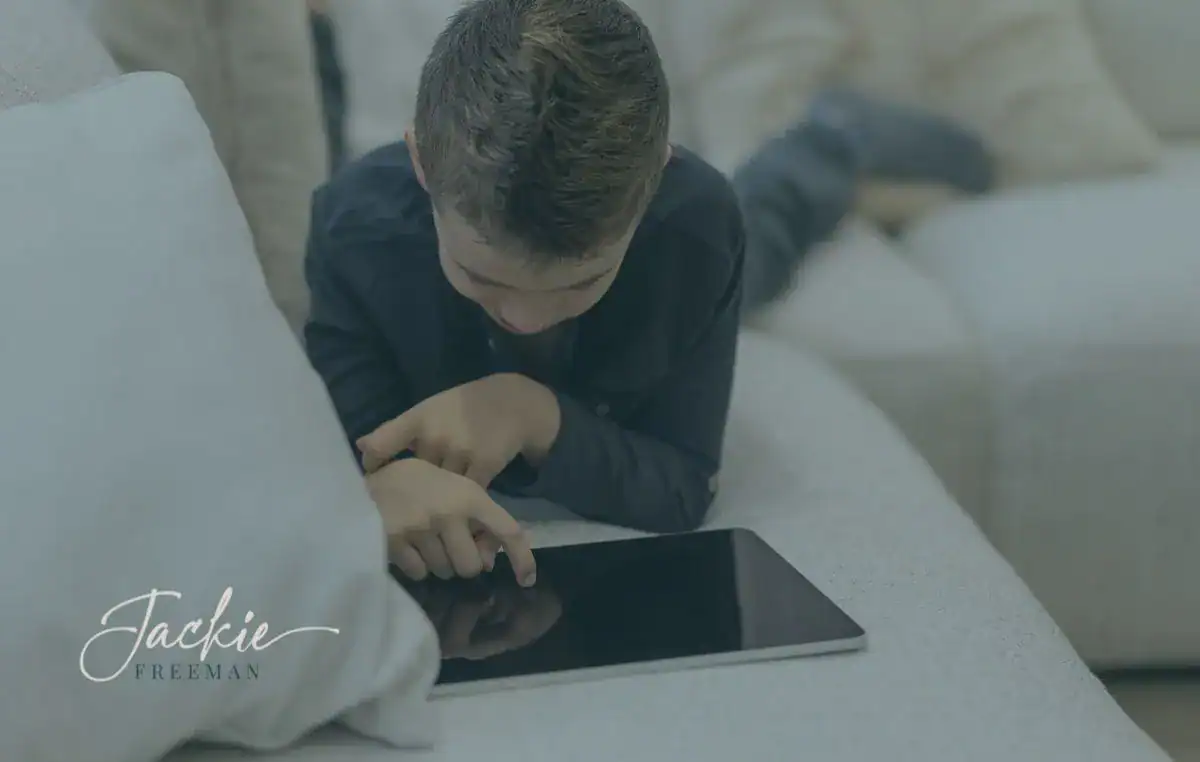 facetime-without-filters Young boy stretched out on couch, using a tablet